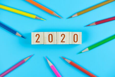 2020 text on wood cube and color pencil on light blue backgroundの写真素材