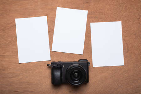 empty photo frames with camera on brown wooden background