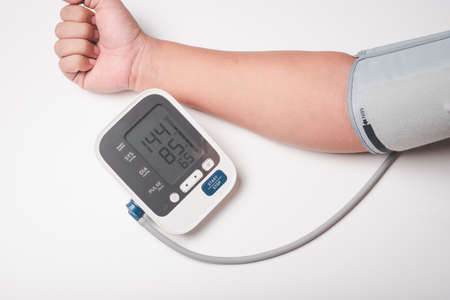 man hand using digital pressure gauge check his blood pressure , digital number showing hypertension...