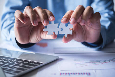 business man hand connecting jigsaw puzzle pieces