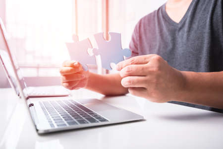 man hand connecting jigsaw puzzle piecesの写真素材