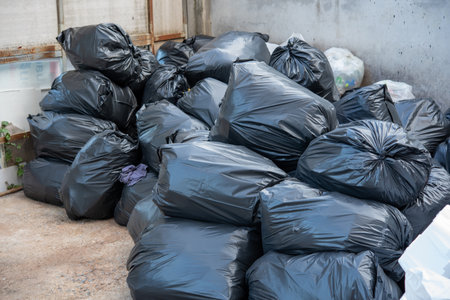 Garbage in black bags waiting to be disposed of.の写真素材