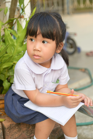 Cute asian child tired of homework at home の写真素材