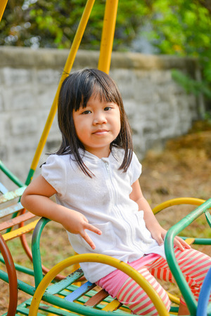 Cute litter girl playing at the playground の写真素材