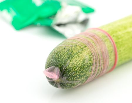 Condom on head of long cucumberの写真素材