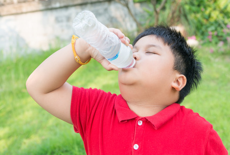 Asian fat boy drinking water.の写真素材