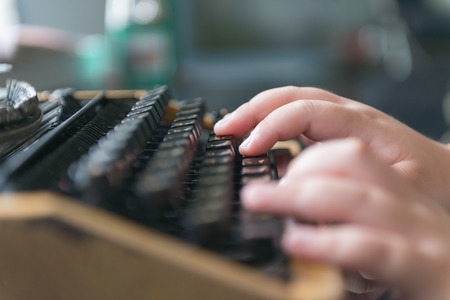 Boy hands writing on old typewriterの写真素材