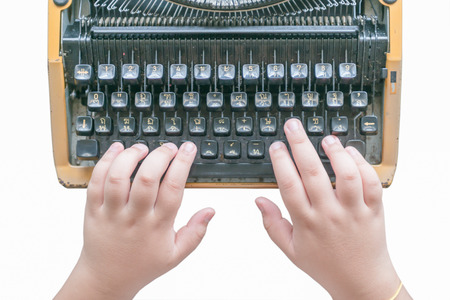 Boy hands writing on old typewriter isolated on whiteの写真素材