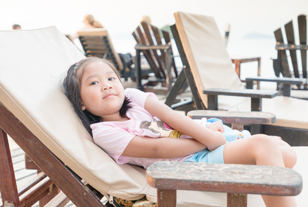 Cute asian girl relax on beach chairsの写真素材
