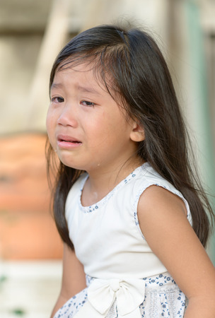 Cute little asian girl crying at home.の写真素材