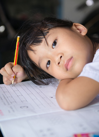 Cute girls is doing her homework.の写真素材