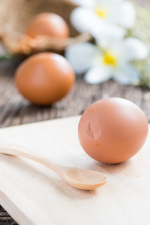 Break eggs on wood plate and spoonの写真素材