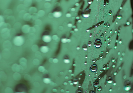 blur of natural water drops on green tone background