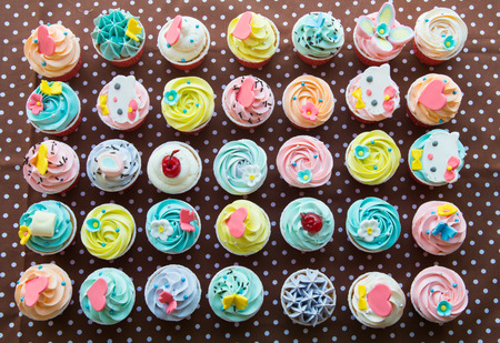 colorful of cup cakes on brown paper