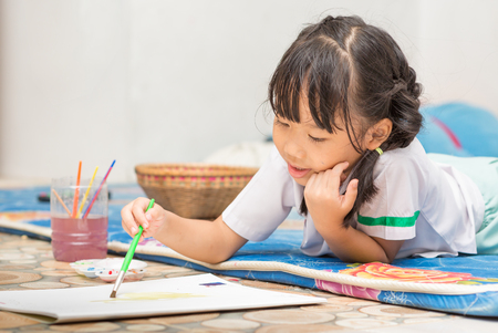 cute girl student enjoy to play paint colorの写真素材
