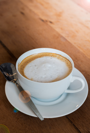 foam milk on hot latte coffee with light flareの写真素材