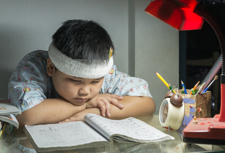 fat boy reading a book for exam on nightの写真素材