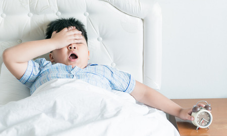 fat boy yawn on bed in morningの写真素材