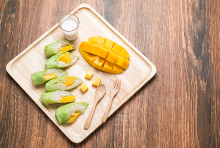Mango with Sticky Rice in crepe cake on wood backgroundの写真素材