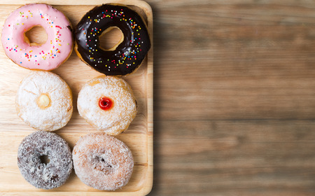 donut on wood plate and blur wood background, with copy space.の写真素材