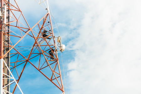 worker work on mobile tower on white cloud and blue sky..の写真素材