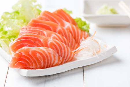 salmon sashimi on white dish and wood background, Japaness food, concept healthy food and diet.の写真素材