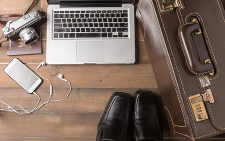prepare accessories and travel items for business man on brown wooden board, flat lay, top view background.の写真素材