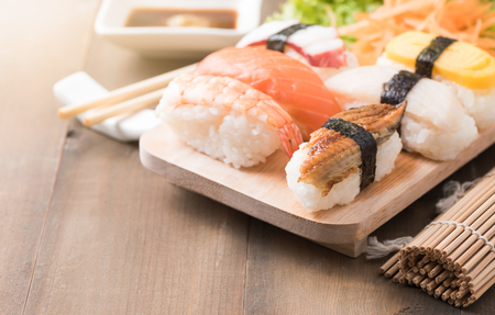 sushi with sauce and wasabi on old brown wood plate, Japanese food.の写真素材