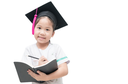 Happy Asian school kid graduate writing book with graduation cap isolated on white background.の写真素材