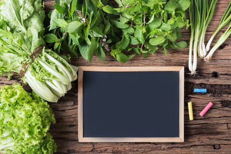 blackbroad and chalk with peppermint, sweet basil, lettuce on old wood background, Thai vegetable.
