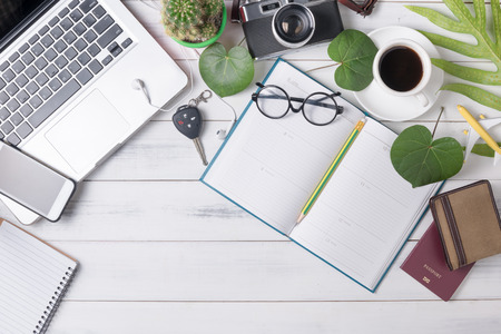 blank calendar with computer, coffee and vintage camera on white wood background, business concept.の写真素材