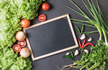 mix vegetable, salad, tomato, spring onion, coriander, chilli with blackboard on black bcakground, ingredient for make food or menu concept.の写真素材