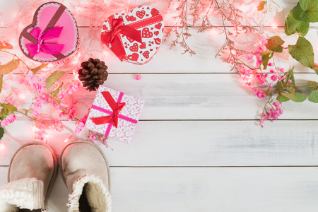 Christmas background, light and gift box with child boots on old wood background, Xmas and New year conceptの写真素材