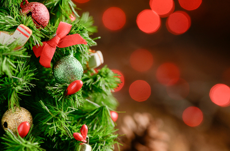 Closed up of Christmas tree with gift on old wood and red light bokeh, Merry Christmas and Happy new year concept.の写真素材