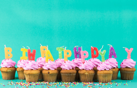 pink cup cake with happy birthday candle on green background, copy space and vintage tone.の写真素材