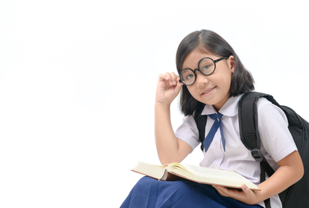 cute asian girl wear eyeglasses reading book isolated on white background, back to school and education concept..の写真素材