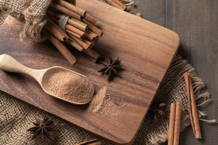 Cinnamon powder mix sugar on wood scoop and cinnamon sticks with star anise spice on wood block, Top view, spices and herb concept..の写真素材