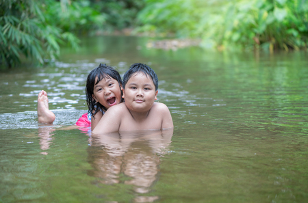 brother and sister playing in river on summer, lifestyle and recreation concept..の写真素材