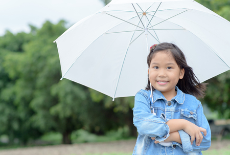 cute asian girl smile and holding white umbrella on nature background, Healthy conceptの写真素材