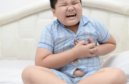 Fat boy with heart attack, pain in chest, overweight child body, Health care conceptの写真素材
