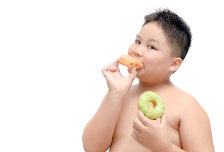 Obese fat boy is eating donut isolated on white background, junk food and dieting concept.の写真素材