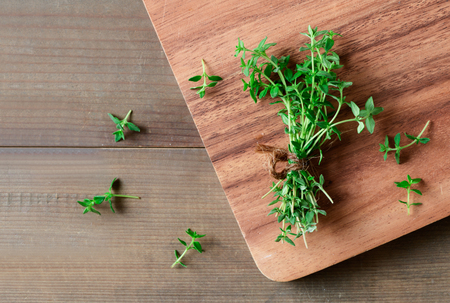 Thyme fresh herb on wood background. It is an aromatic perennial evergreen herb with culinary, medicinal, and ornamental usesの写真素材