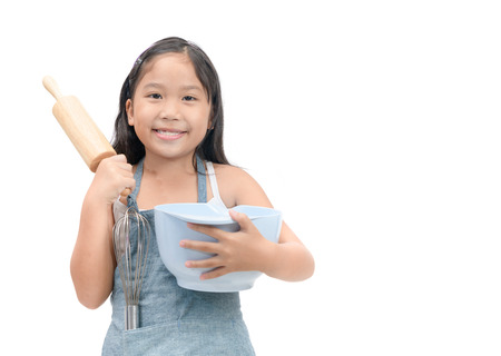 Cute asian girl holding cooking utensils isolated on white background.の写真素材