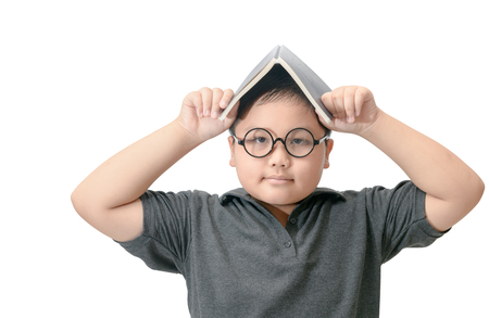 Fat boy student holding book on his head isolated on white  background, education and back to school conceptの写真素材