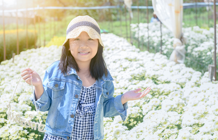 Happy little girl holding a bouquet of colorful chrysanthemum flower, lifestyle and travel concept.の写真素材