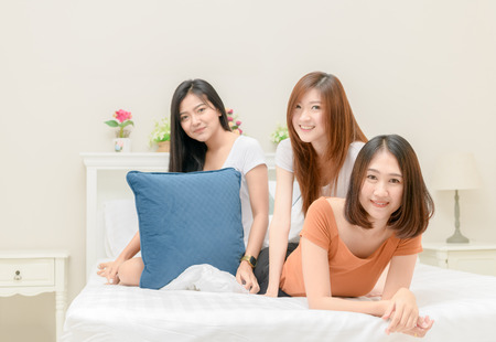 portrait of three pretty girls smile on bed, lifestyle and relaxationの写真素材