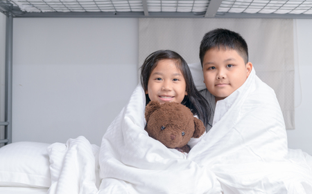 Brother and sister sitting in blanket, Happy time concept.の写真素材