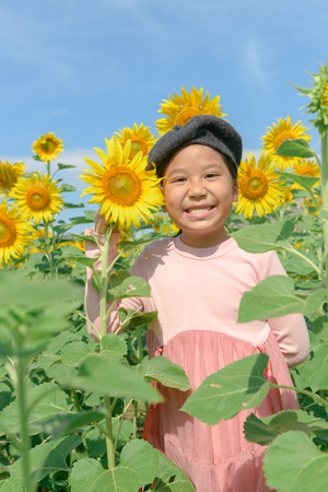 cute Asian girl smile with sunflower flower in farm, Happy and lifestyle concept.の写真素材