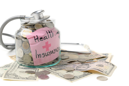 Stethoscope on a jar contains coins and banknoteの写真素材