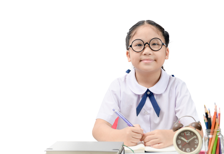 Cute asian student doing homework on table isolated and copy space on whiteの写真素材
